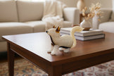 Glass fox figurine with a white base and black-tipped ears on a light beige background