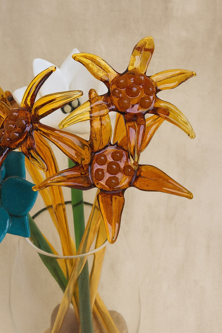 Glass sunflower decorations in a clear vase on a beige background