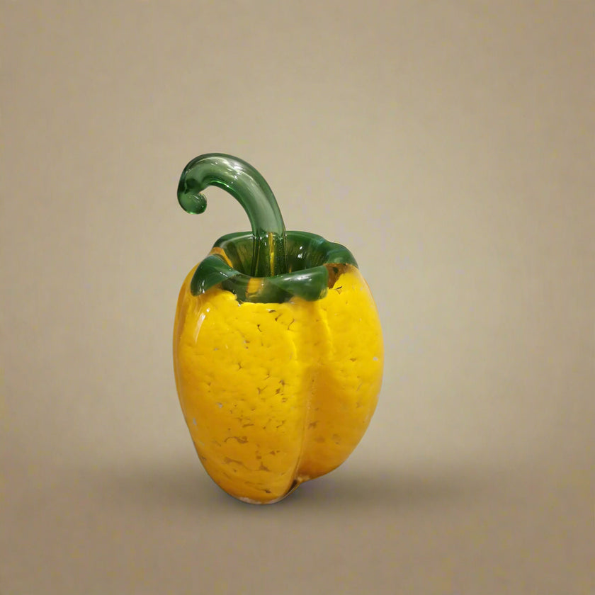 Handblown glass bell pepper decoration with a vibrant yellow finish and green top.