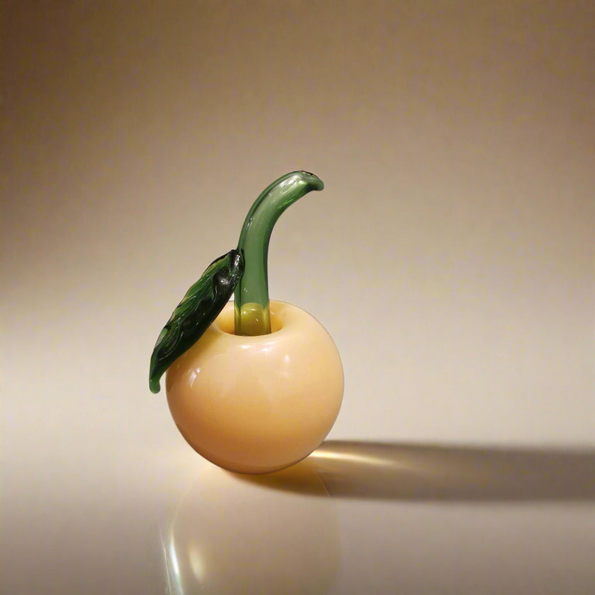 A handblown glass apple decoration with a leaf, resembling a cherry apple, in a Murano style.