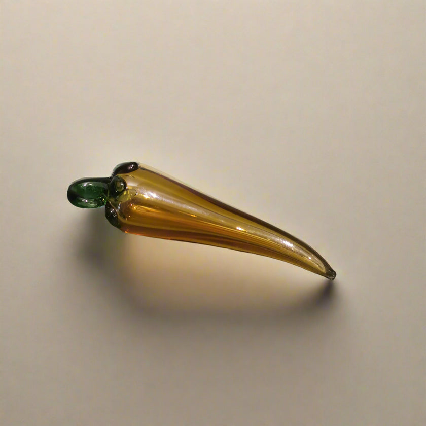 Handblown glass chilli pepper decoration with a amber color and green stem.