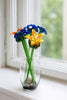 Glass flowers in a clear vase on a windowsill