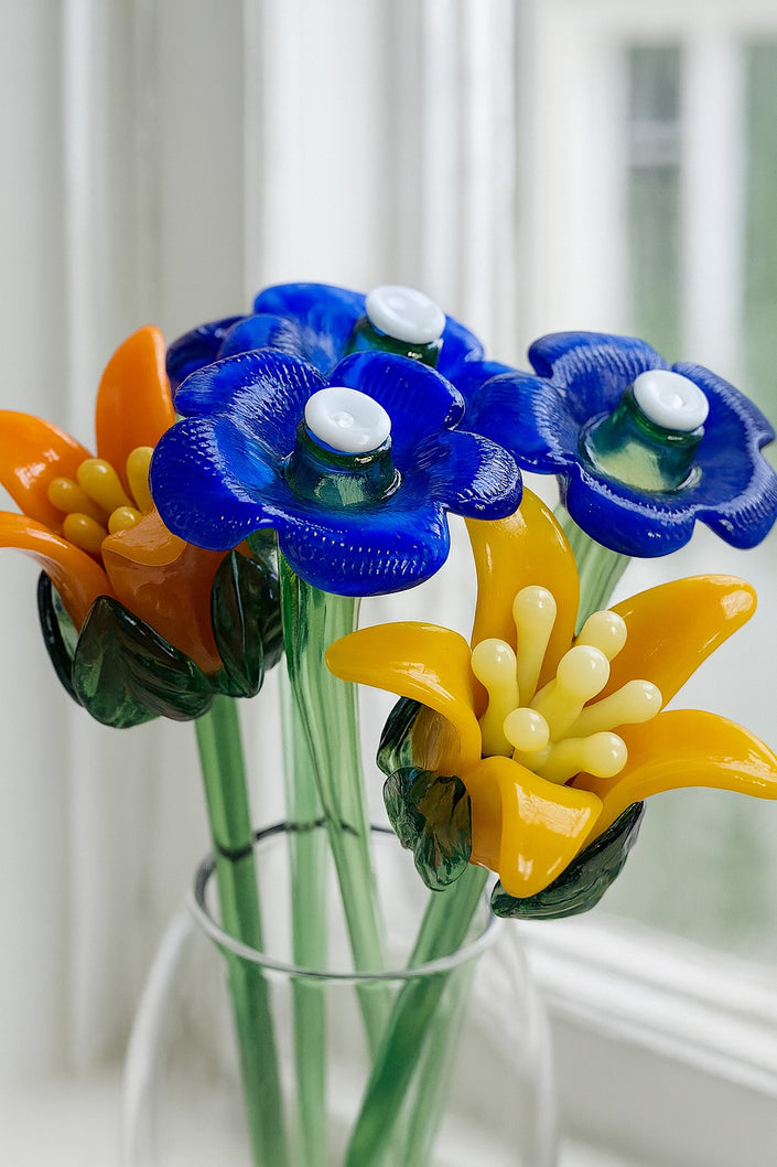 Bouquet of glass flowers in blue, orange, and yellow with a blurred white background