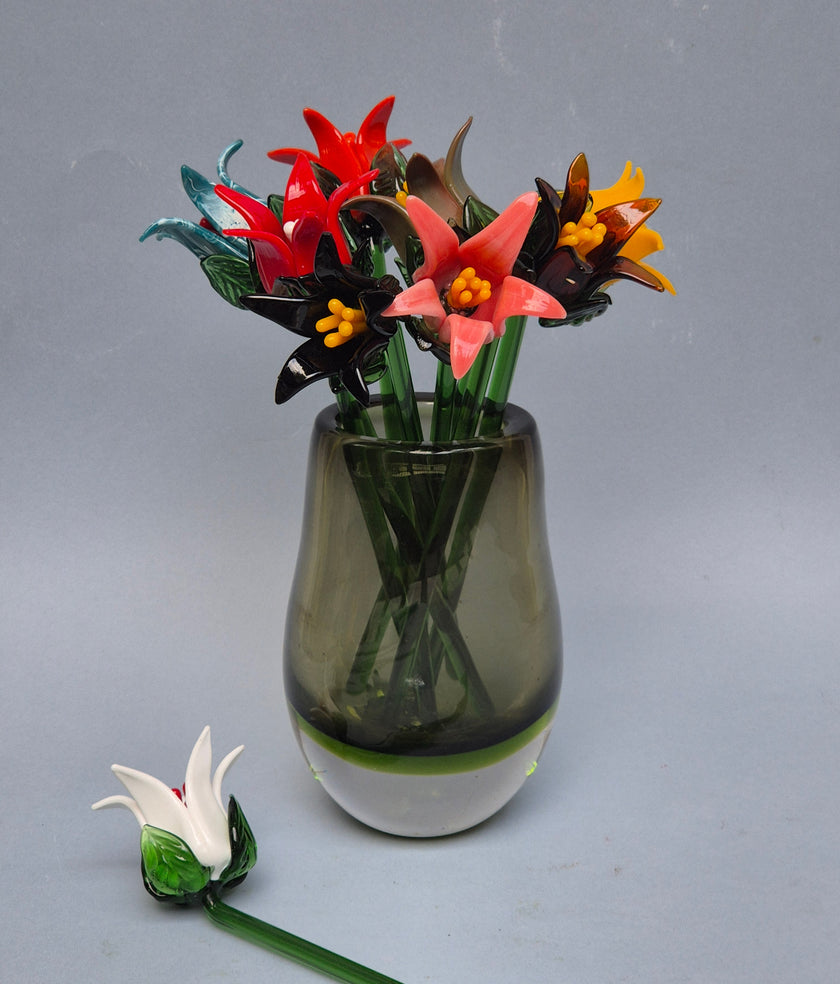 Glass flower arrangement in a vase on a gray background